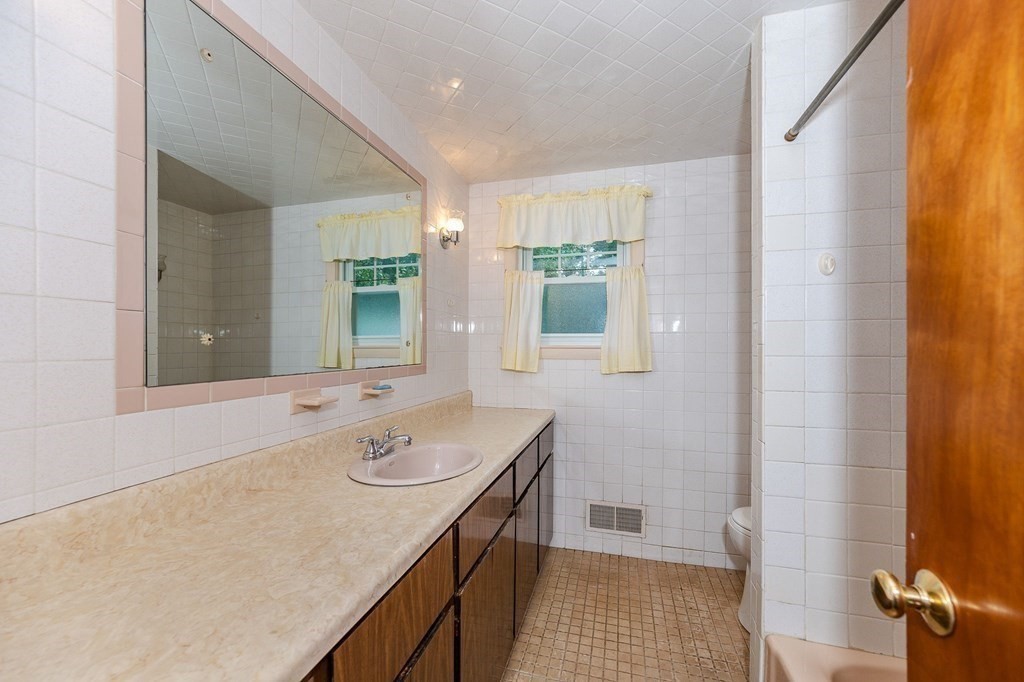 60 Rangeway Road Billerica, MA 01862 - Photo 8 of 36 a bathroom with a sink a mirror and a shower
