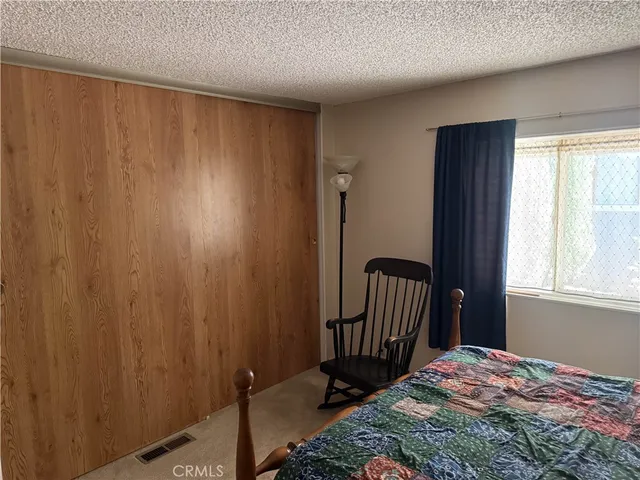 a bedroom with a window and a wooden floor
