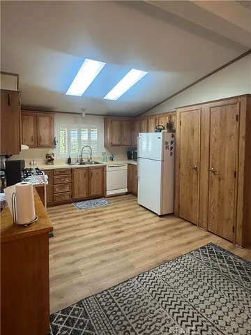 a large kitchen with a refrigerator a stove top oven a sink and dishwasher