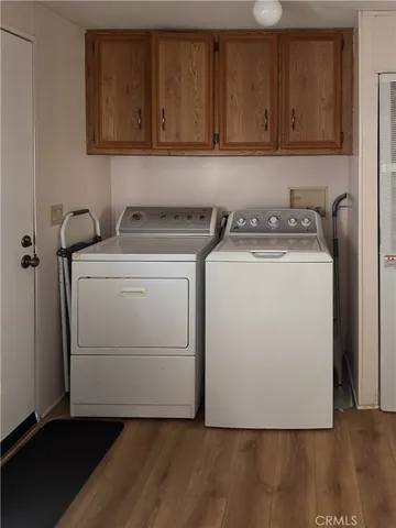 a utility room with wooden floor washer and dryer