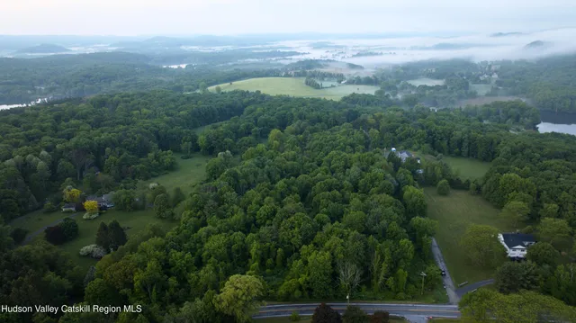 an aerial view of residential houses with outdoor space and trees