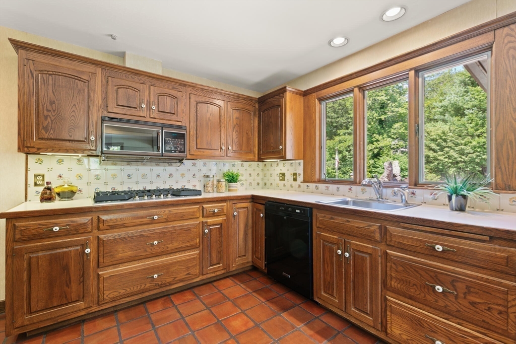 77 Wellesley Road Belmont, MA 02478 - Photo 12 of 31 a kitchen with granite countertop wooden cabinets stainless steel appliances a sink and a large window