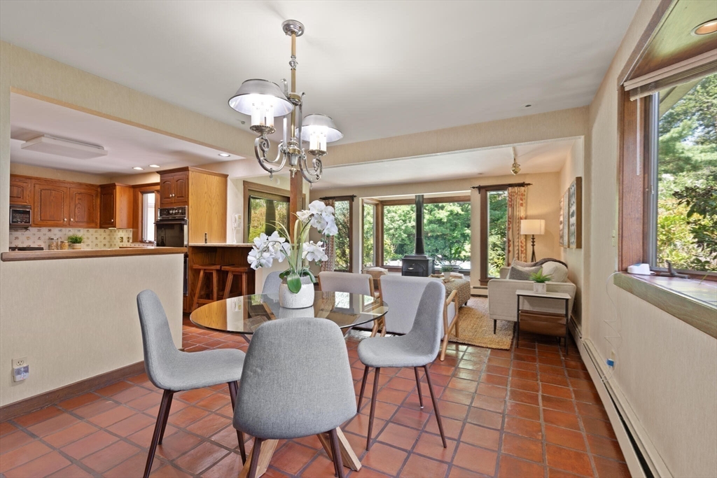 77 Wellesley Road Belmont, MA 02478 - Photo 15 of 31 a dining room with wooden floor a chandelier a glass table and chairs