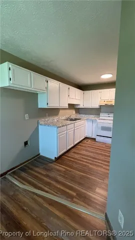 a view of a kitchen with kitchen island and stainless steel appliances