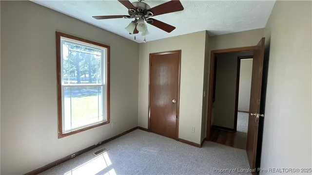 an empty room with windows and closet