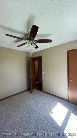 a view of a livingroom with a ceiling fan and window
