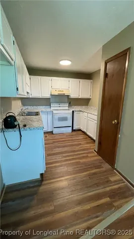 a kitchen with stainless steel appliances granite countertop a refrigerator a stove and a wooden floors