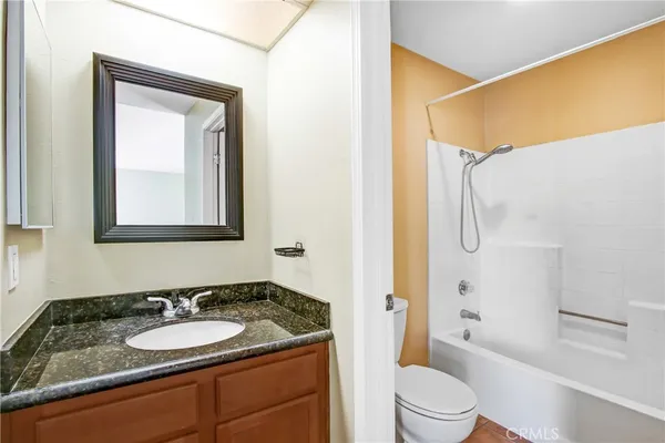 a bathroom with a granite countertop sink toilet and shower