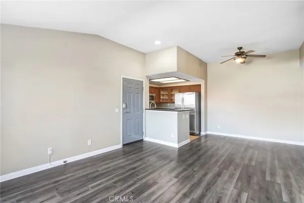 a view of a kitchen with a fridge and wooden floor