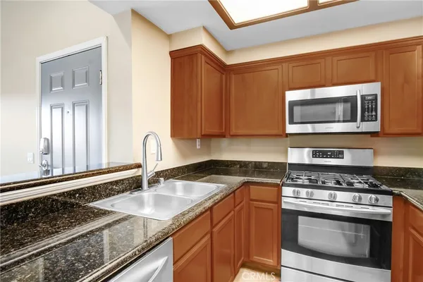 a kitchen with stainless steel appliances granite countertop a sink stove and microwave