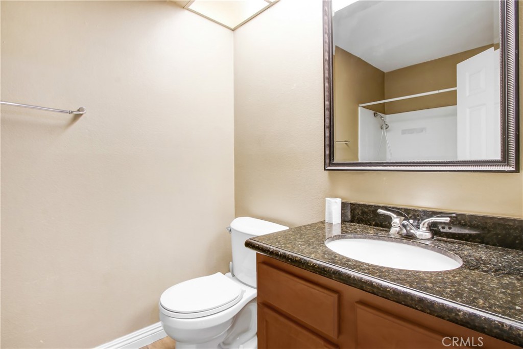 200 East Alessandro Boulevard, Unit 106 Riverside, CA 92508 - Photo 8 of 16 a bathroom with a granite countertop sink toilet and a mirror