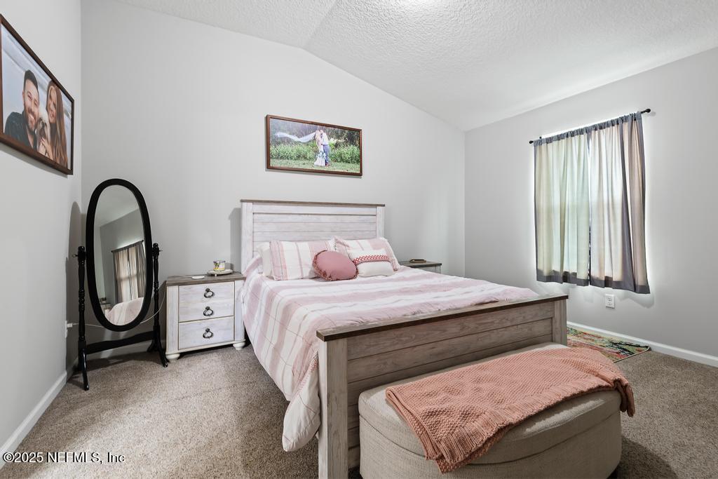 87267 Lents Road Yulee, FL 32097 - Photo 14 of 28 a bedroom with a bed and a potted plant on the dresser