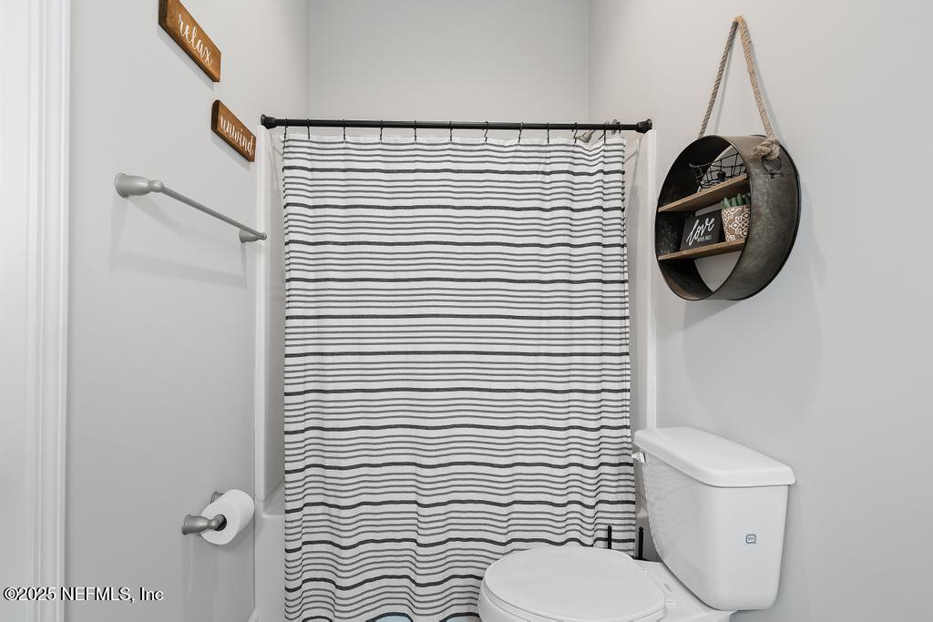 87267 Lents Road Yulee, FL 32097 - Photo 17 of 28 a bathroom with a toilet and a shower curtain