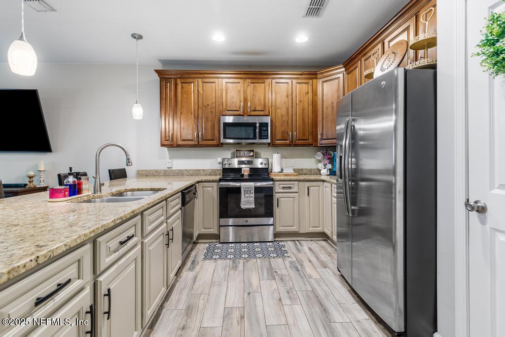 87267 Lents Road Yulee, FL 32097 - Photo 7 of 28 a kitchen with granite countertop a refrigerator stove top oven and sink