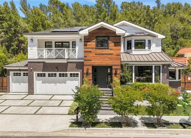 a front view of a house with a yard and trees