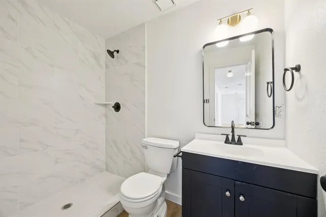 a bathroom with a sink a toilet and shower