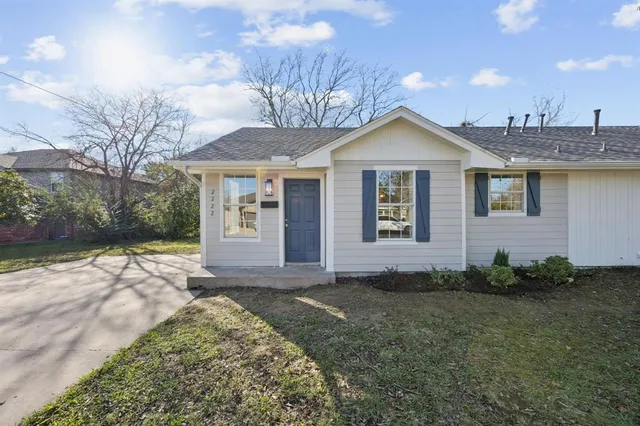 a view of a house with a yard and potted plants