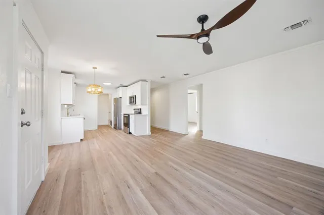 a view of a big room with wooden floor and windows