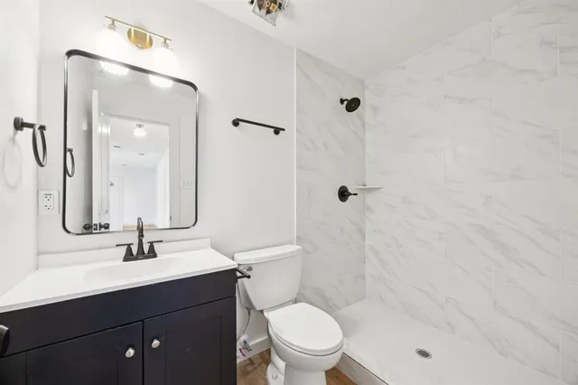 a bathroom with a sink a toilet and shower