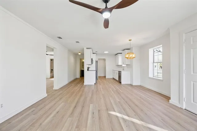 a view of empty room with wooden floor and window