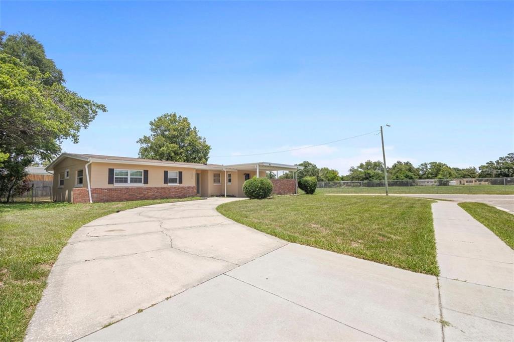 5825 Forest Grove Boulevard Orlando, FL 32808 - Photo 13 of 19 a front view of a house with a yard
