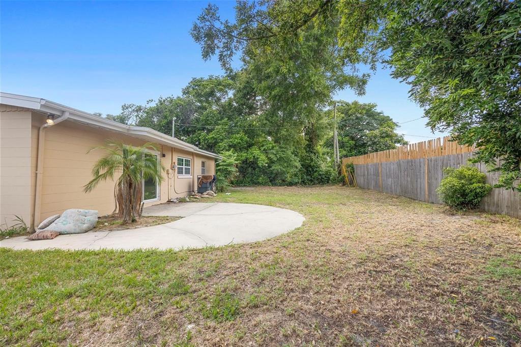 5825 Forest Grove Boulevard Orlando, FL 32808 - Photo 17 of 19 a view of a house with a yard and potted plants