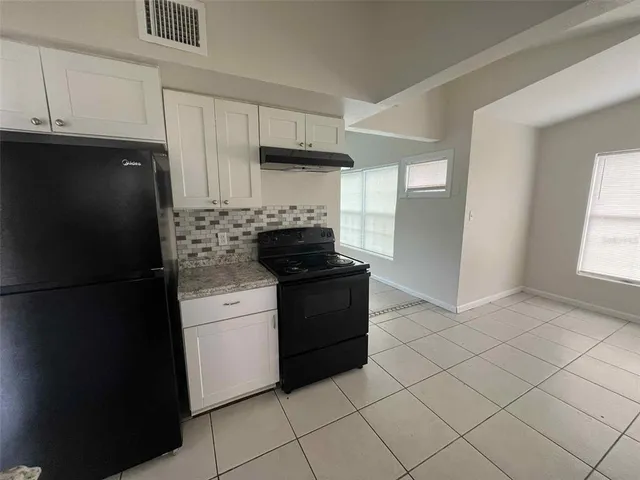 a kitchen with a refrigerator stove and cabinets