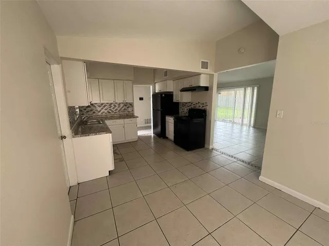 a view of kitchen with refrigerator and cabinets