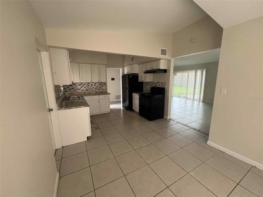 5825 Forest Grove Boulevard Orlando, FL 32808 - Photo 5 of 19 a view of kitchen with refrigerator and cabinets