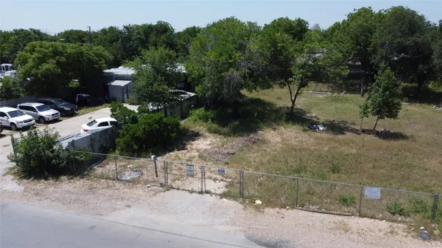 a view of a street with plants and a bench