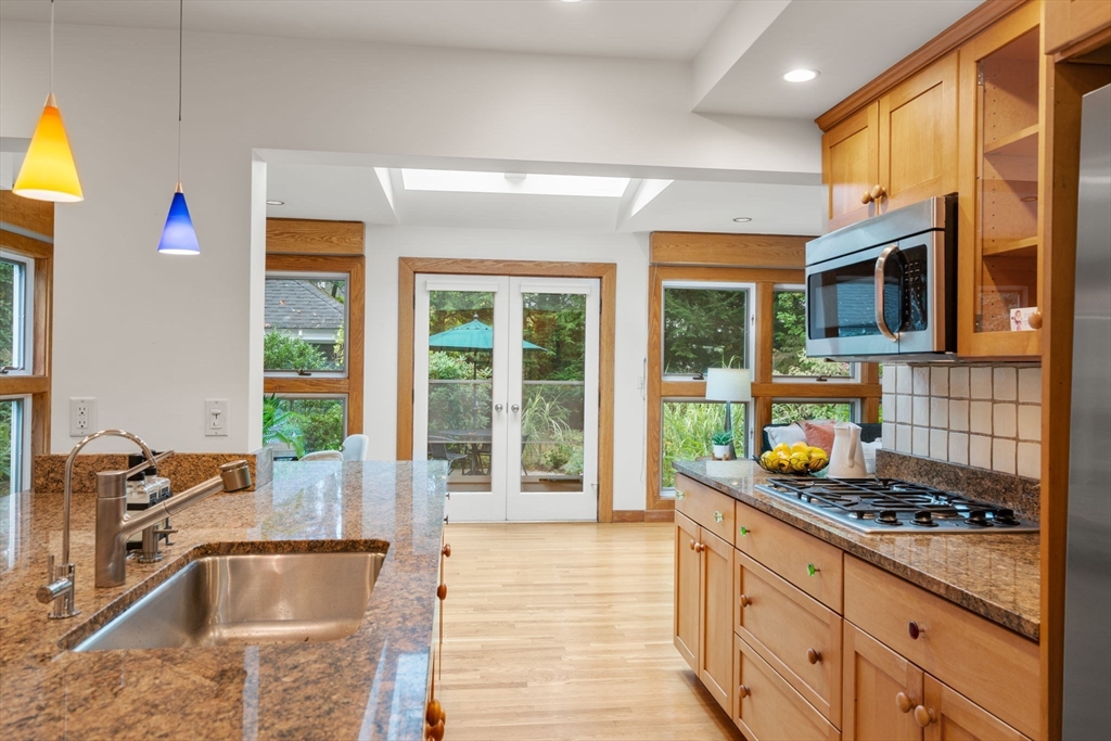 151 Woodcliff Road Newton, MA 02461 - Photo 4 of 33 a kitchen with stainless steel appliances granite countertop a sink and a stove next to a window