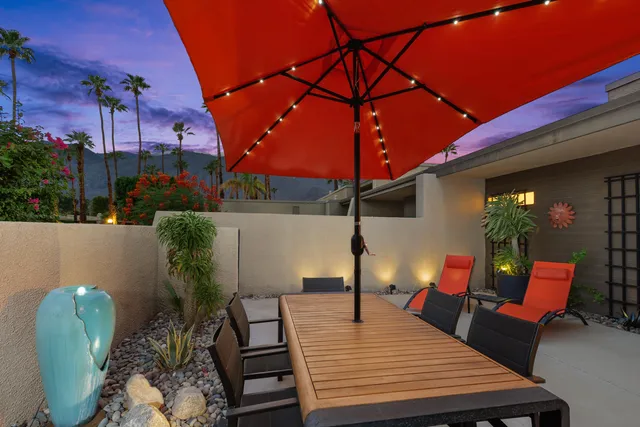 a backyard of a house with table and chairs