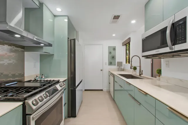 a kitchen with stainless steel appliances granite countertop a sink and a stove