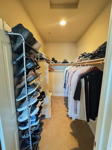 a view of walk in closet with clothes and shoes
