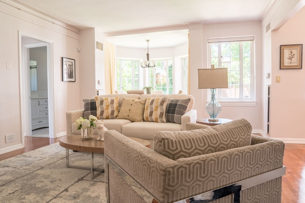 20 Chapel Street, Unit B411 Brookline, MA 02446 - Photo 2 of 18 a living room with furniture a wooden floor and a large window