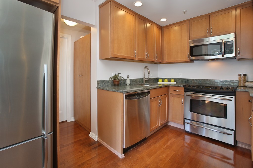 20 Chapel Street, Unit B411 Brookline, MA 02446 - Photo 4 of 18 a kitchen with stainless steel appliances granite countertop a stove a microwave and a refrigerator