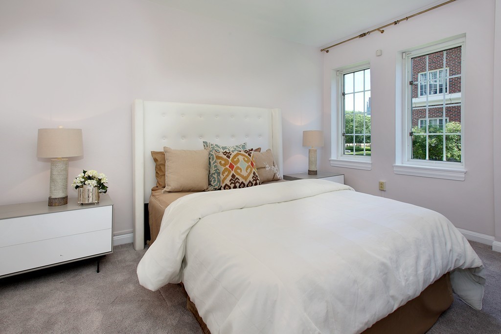 20 Chapel Street, Unit B411 Brookline, MA 02446 - Photo 9 of 18 a large bed sitting in a bedroom next to a window