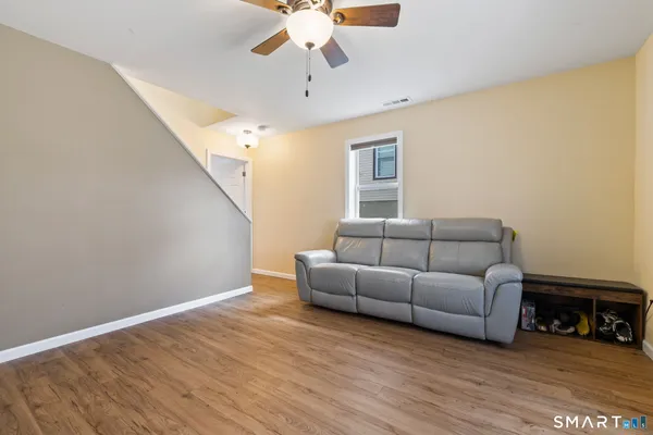 a living room with furniture and a wooden floor