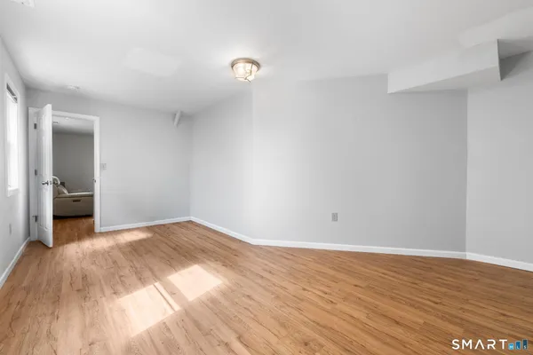 a view of a livingroom with wooden floor and a bathroom