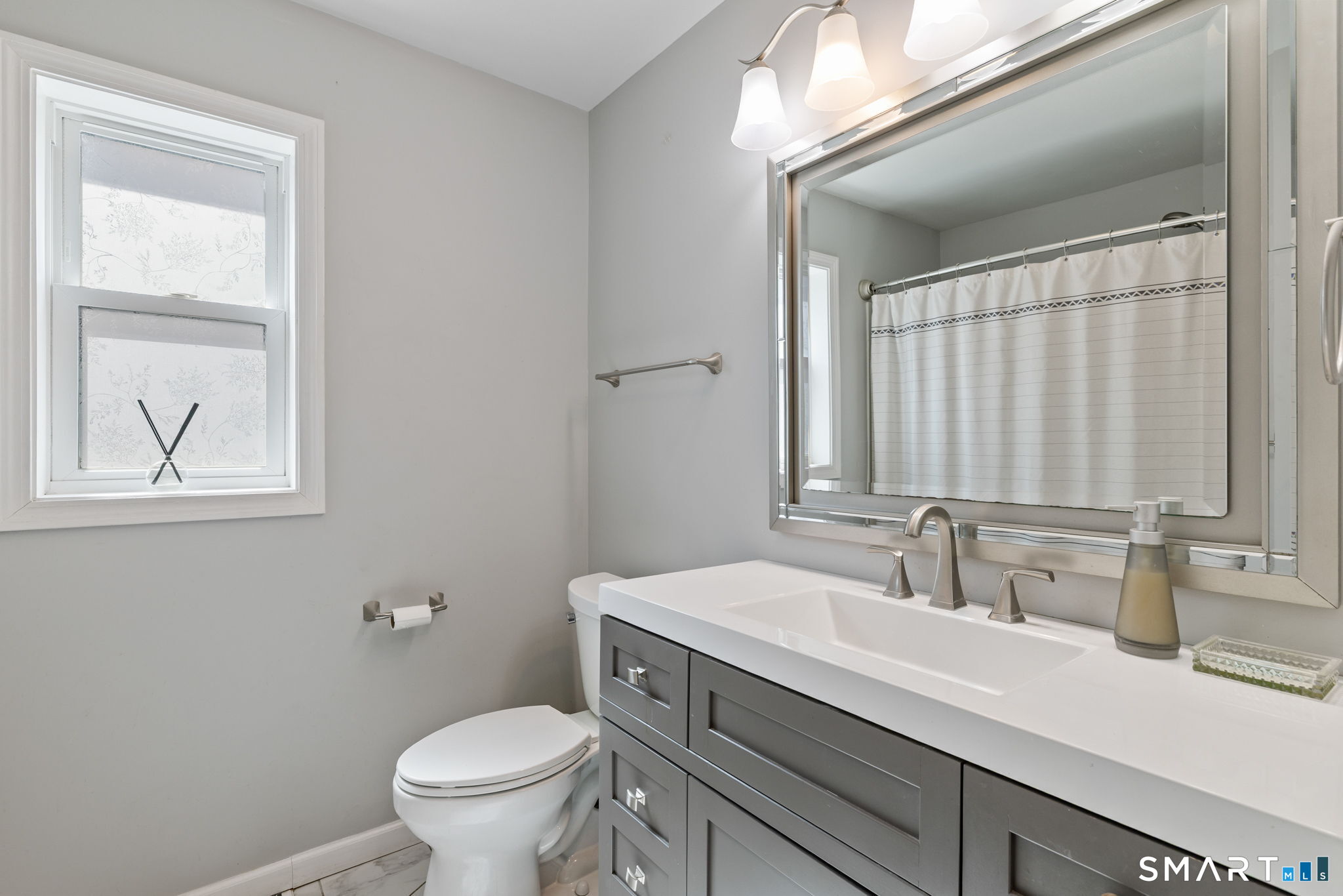 132 Howard Avenue Ansonia, CT 06401 - Photo 40 of 41 a bathroom with a toilet a sink a mirror a and a window