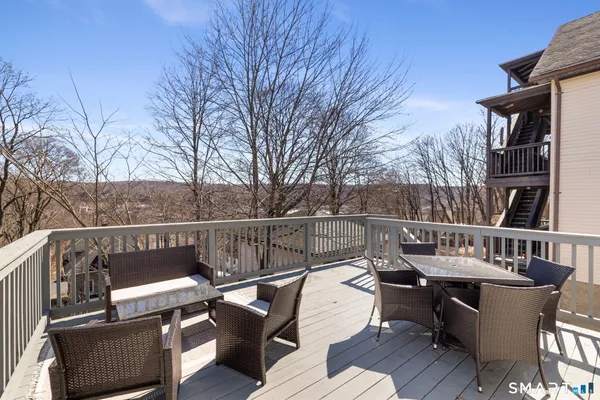 a view of a roof deck with couches and wooden floor