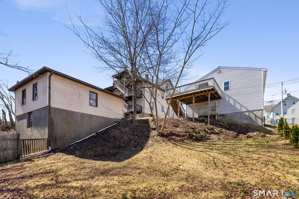 a backyard of a house with large trees and buildings