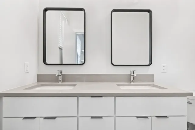 an aerial view of a residential houses with outdoor space and trees