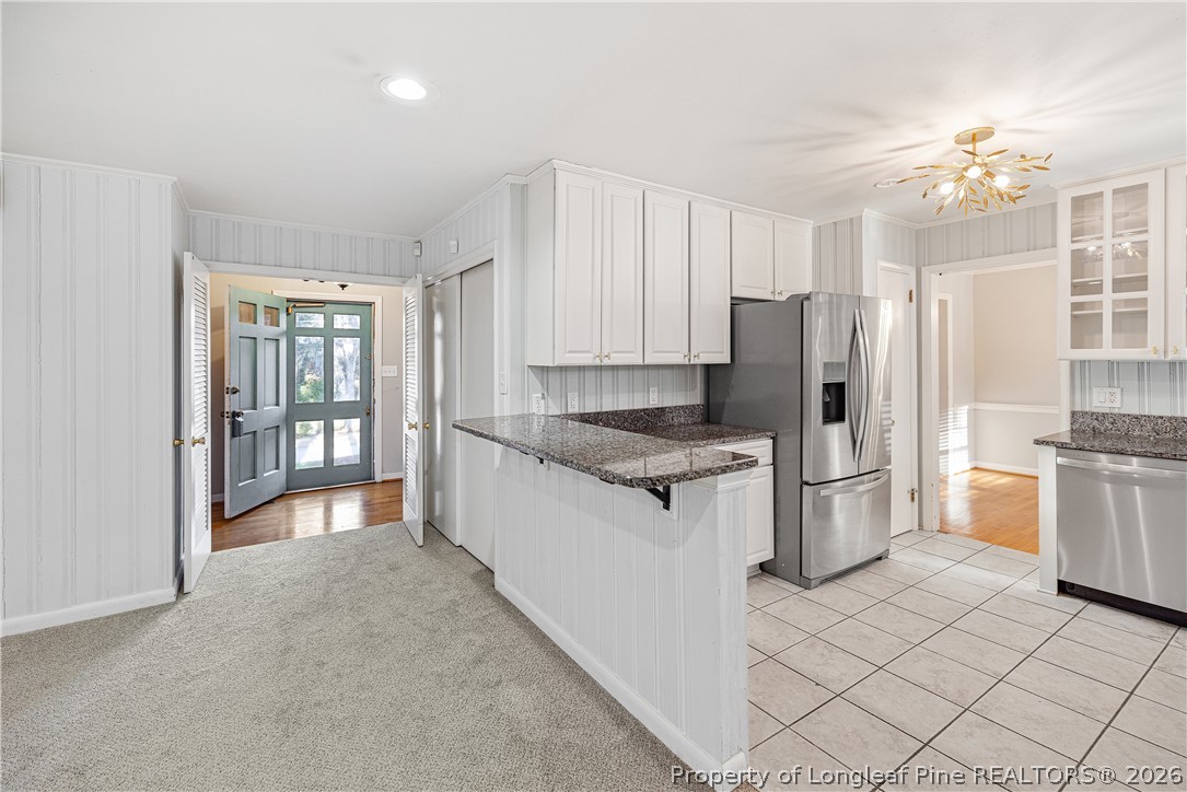 2527 Huntington Road Fayetteville, NC 28303 - Photo 13 of 39 a large kitchen with a refrigerator a stove a sink dishwasher with a dining table and chairs