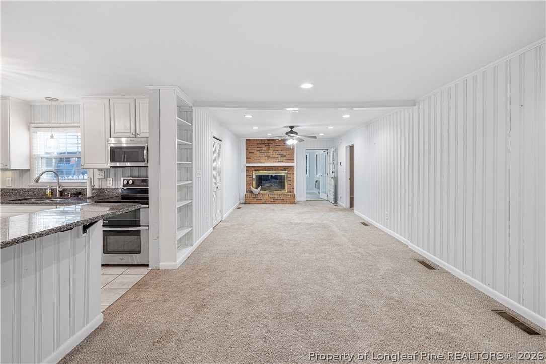 2527 Huntington Road Fayetteville, NC 28303 - Photo 16 of 39 a view of a kitchen with a sink and dishwasher a refrigerator with wooden floor