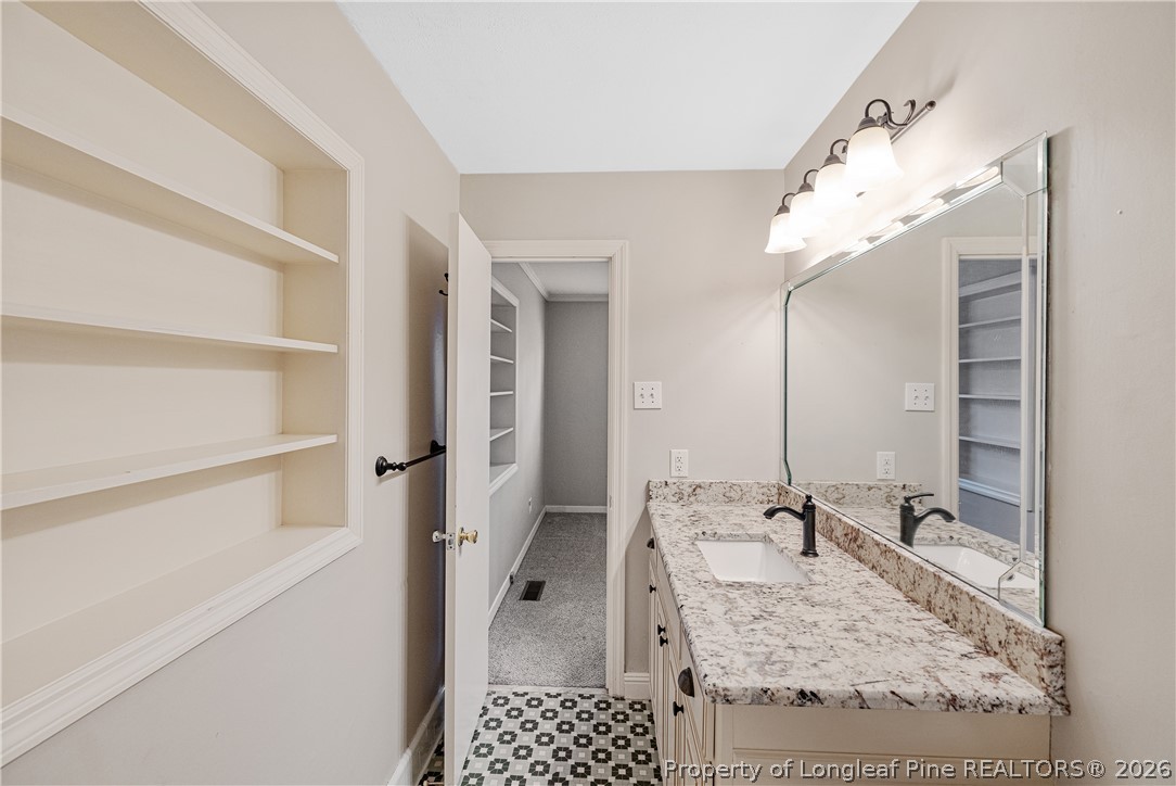 2527 Huntington Road Fayetteville, NC 28303 - Photo 32 of 39 a bathroom with a granite countertop sink a mirror and shower