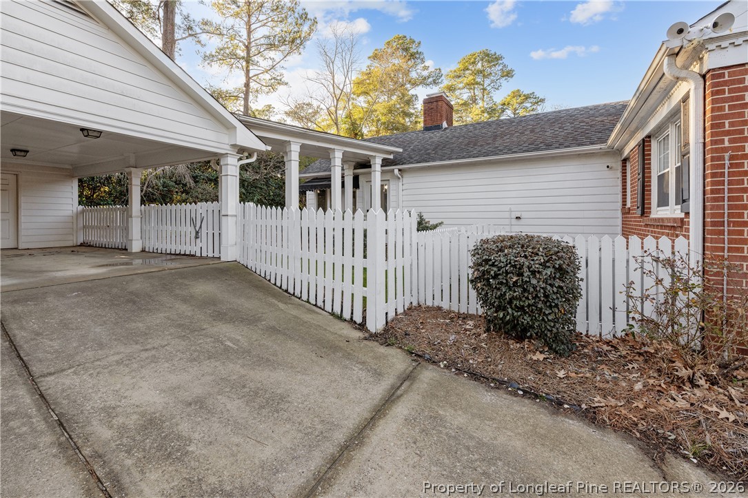 2527 Huntington Road Fayetteville, NC 28303 - Photo 37 of 39 a view of a white house with large windows and flower plants