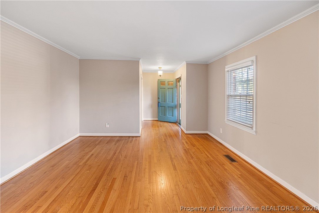 2527 Huntington Road Fayetteville, NC 28303 - Photo 5 of 39 a view of an empty room with wooden floor and a window