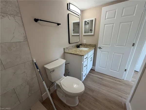 a bathroom with a granite countertop toilet and a sink