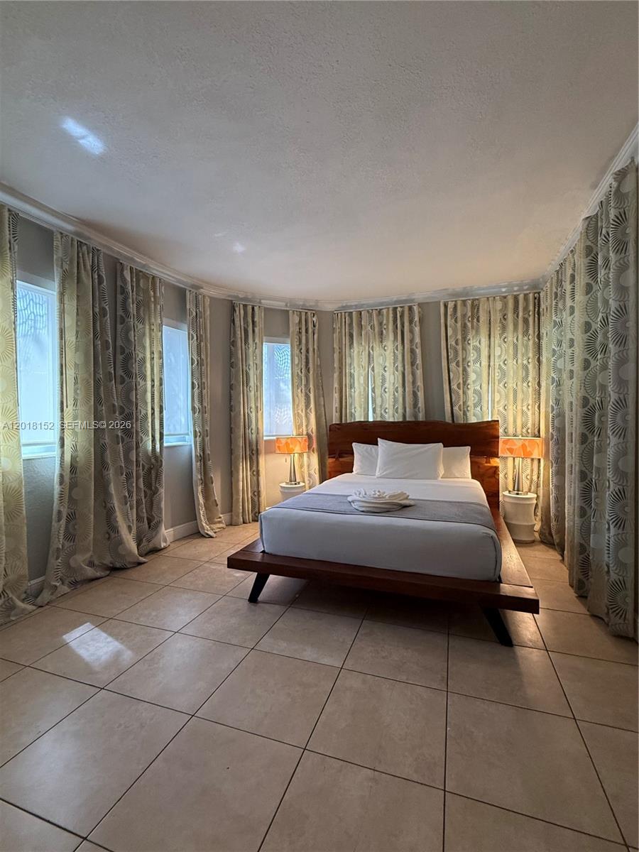 7710 Harding Avenue, Unit 7 Miami Beach, FL 33141 - Photo 6 of 9 a bedroom with a bed and a window